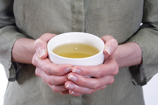 woman holding cup of green tea