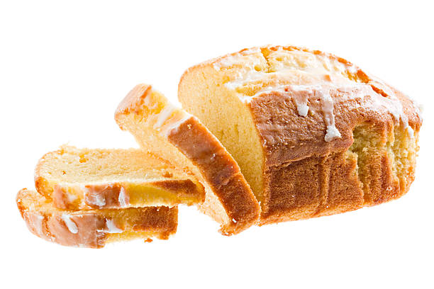 Pound Cake A close up of a frosted lemon pound cake loaf with several slices cut off. Isolated on white. pound cake stock pictures, royalty-free photos & images