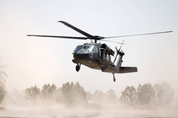 Black Hawk helicopter hovering above a dusty ground stock photo