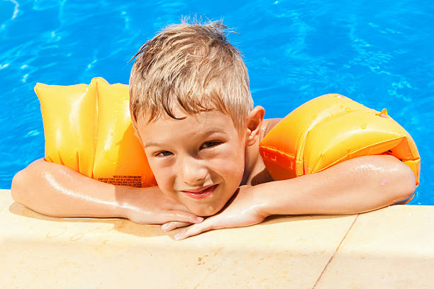 istock Child with water wings relaxing the swimming pool 184927100
