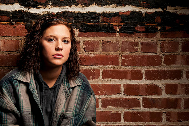 Girl looking sad Female sitting on ground looking at camera runaway stock pictures, royalty-free photos & images