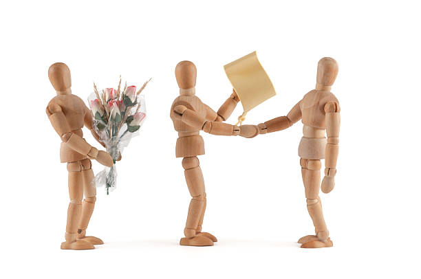 Wooden Mannequin congratulate with certificate wooden mannequins congratulate another mannequin and has a certificate. Why? Success? Honor?  be creative too :) schenken stock pictures, royalty-free photos & images