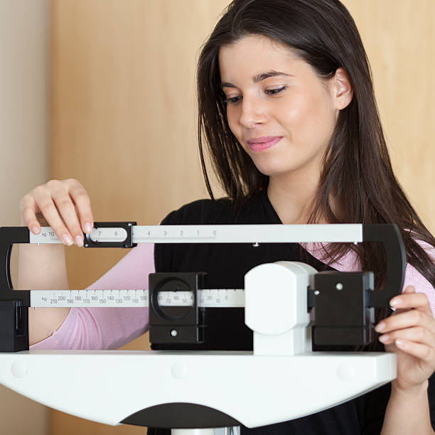 istock woman on the scale 184927696