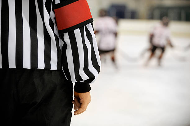 Ice hockey referee Ice hockey referee in front of players with copy space.Click on an referee stock pictures, royalty-free photos & images