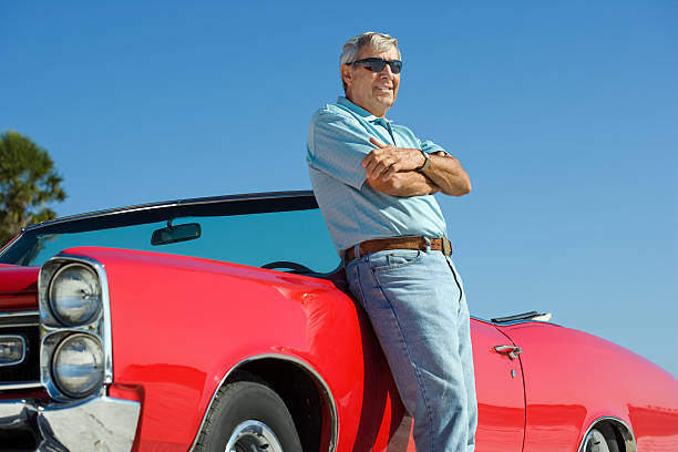 istock Senior with classic convertible car 184928923
