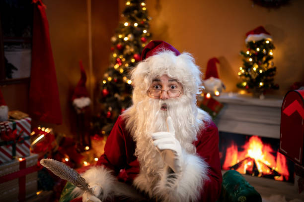 istock Santa Claus looking through spectacles in Christmas room with tree 1849291467