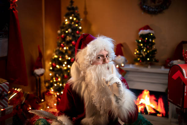 istock Santa Claus looking through spectacles in Christmas room with tree 1849292002