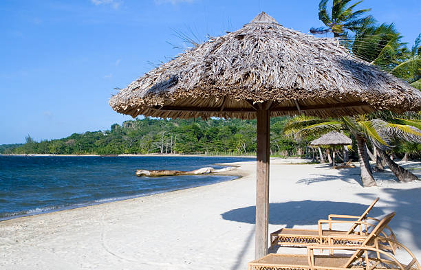 istock Thatched umbrella and chairs on tropical beach 184929365