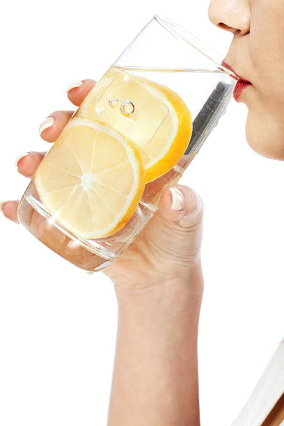 Woman drinking water with lemon, side view, isolated on white background with copy space