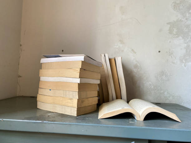 istock Opened book and stacks of old books 1849296338
