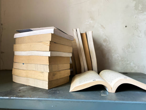 istock Opened book and stacks of old books 1849296877