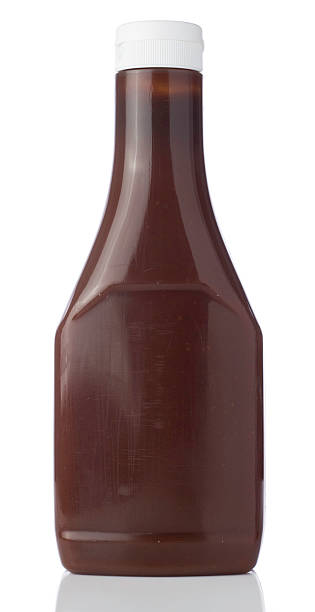 Blank bottle containing a brown liquid with a squirt top lid A bottle of brown Sauce bottle isolated on a white background barbeque sauce photos stock pictures, royalty-free photos & images