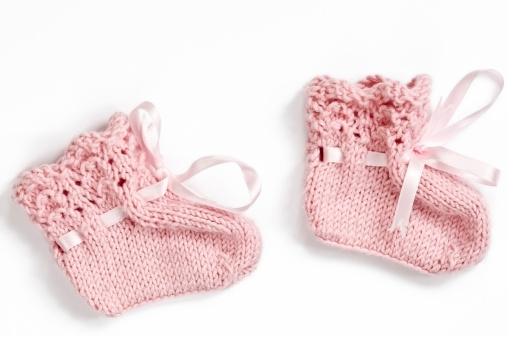Royalty free stock photo of pair pink baby booties on white backgroundSee More in