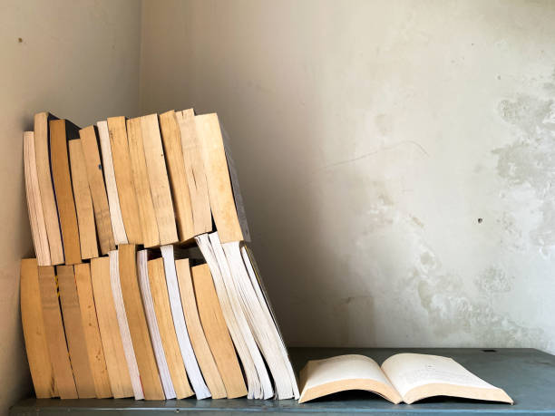 istock Opened book and stacks of old books 1849299029
