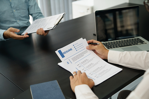 Examiner reading a resume during job interview at office Business and human resources concept