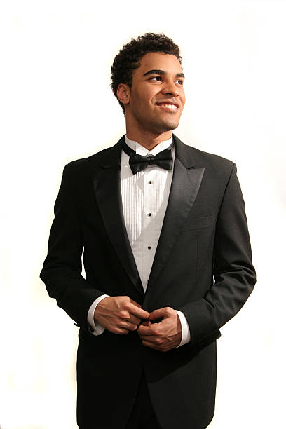 Happy prom date Young minority guy in a tuxedo isolated on white tuxedo photos stock pictures, royalty-free photos & images