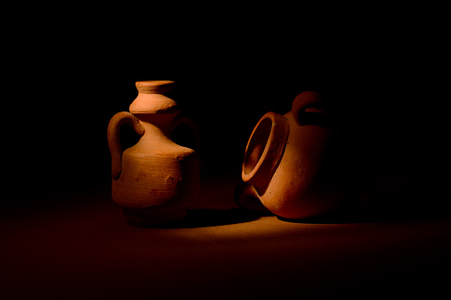 Terracotta amphorae on dark background