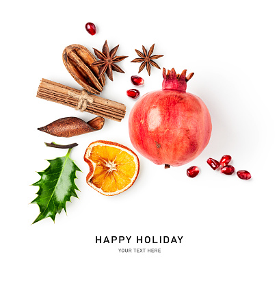 Holly leaf, pomegranate, orange slice and anise stars isolated on white background. Christmas decoration. Holiday symbol. Creative layout. Design element. Flat lay, top view