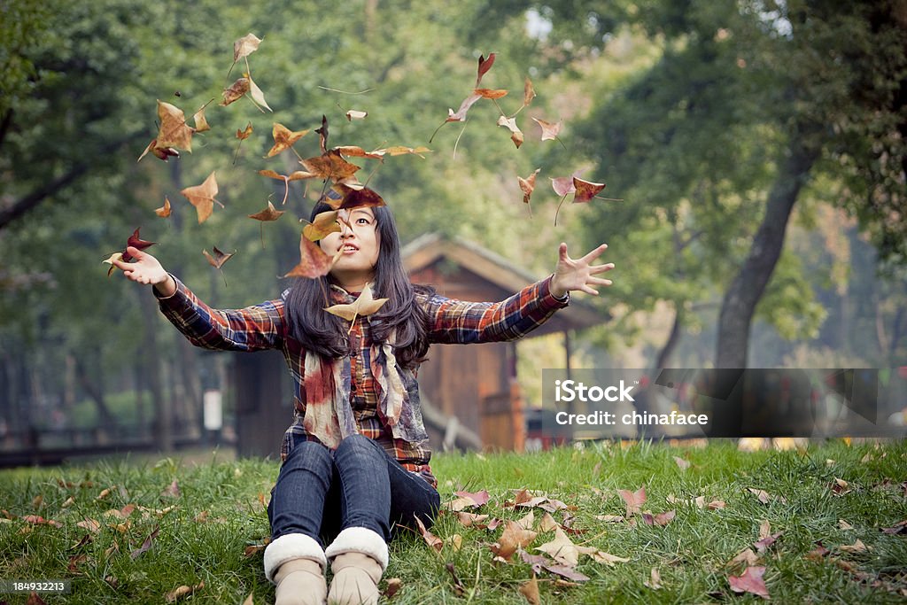 Mulher asiática jovem feliz jogar maple folhas ao ar livre. - Royalty-free 20-29 Anos Foto de stock