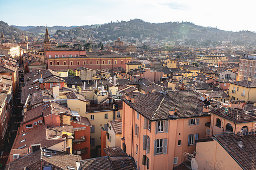 Rooftops of buildings and residential houses with hills in the background in Bologna, Italy