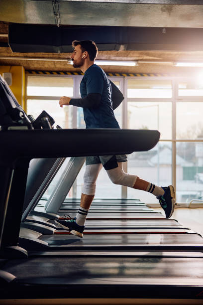 istock Male athlete running in treadmill in a gym. 1849329054