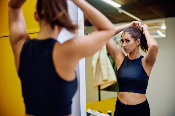 istock Athletic woman tying up a ponytail while preparing for gym workout. 1849329055