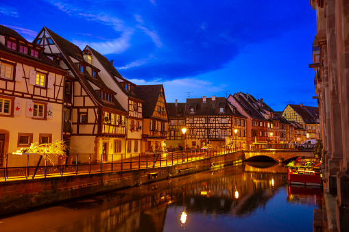 Beautiful Colmar town called Little Venice with traditional half timbered houses along riverbank during night,France