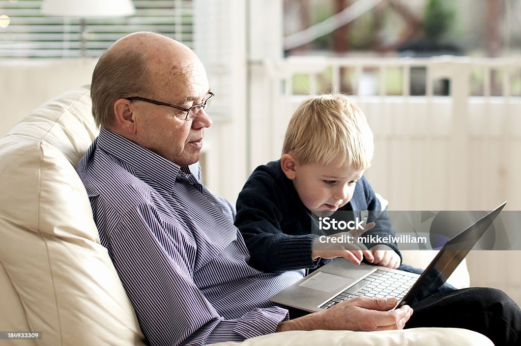 Neto mostra avô como usar um pc - Foto de stock de 4-5 Anos royalty-free