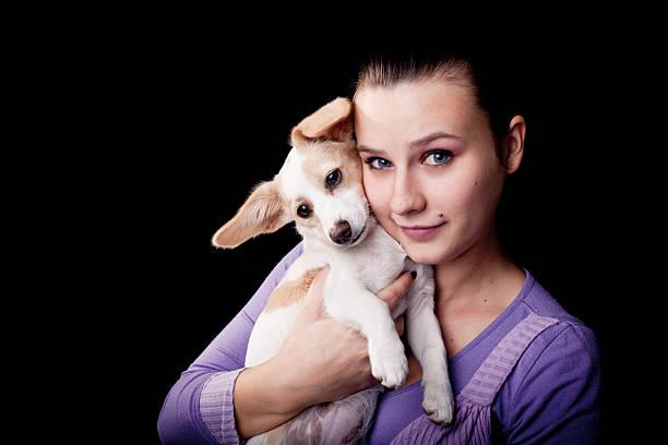 Young Caucasian woman with her pet dog on the grass lawn.