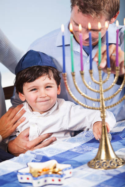 istock Little boy sitting on father's lap celebrating Hanukkah 184933977