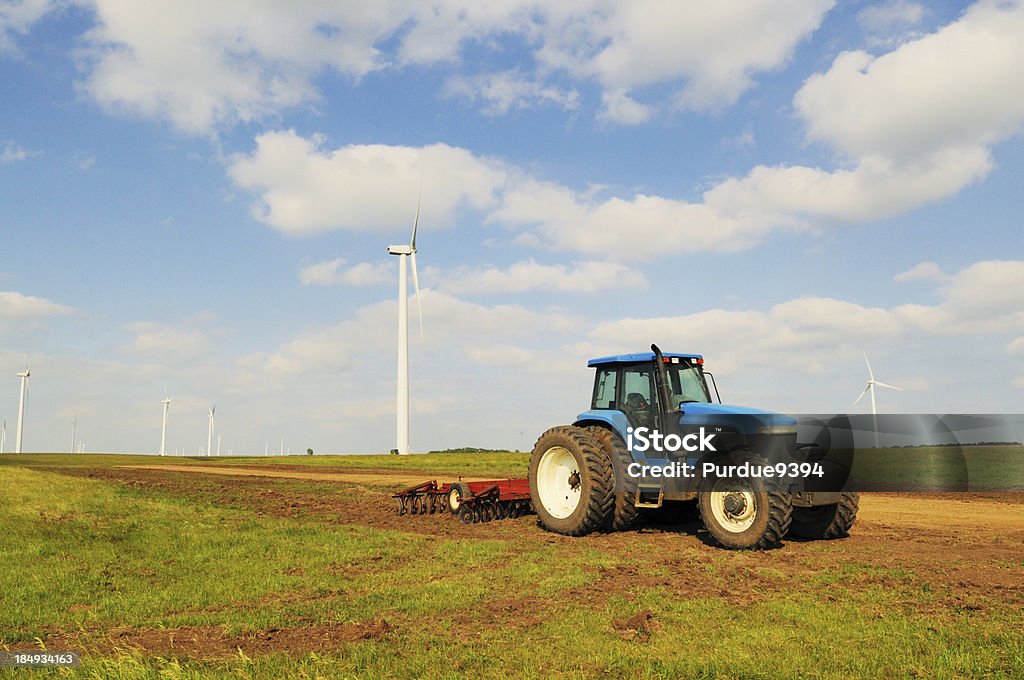 Blue gospodarstwa ciągnika i Cultivator z Turbina wiatrowa Stan Dakota Południowa - Zbiór zdjęć royalty-free (Traktor)