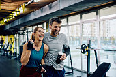 Cheerful athletic couple having sports training in a gym.