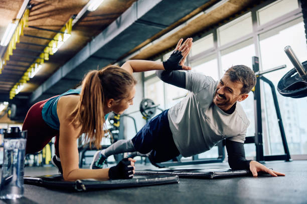 istock Happy athletic couple giving high five while practicing in plank position in a gym. 1849343955