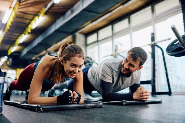 istock Happy athletic couple exercising in plank position in a gym. 1849343959