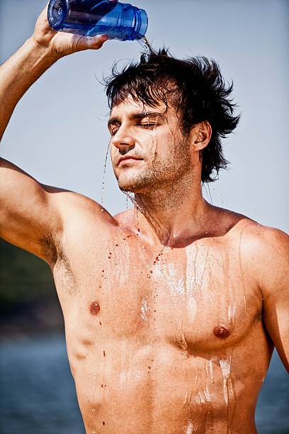 istock Young brazilian man pouring water on his head after workout 184934419