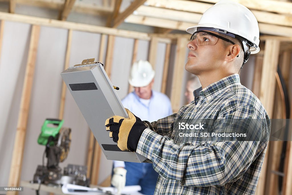 Construction foreman inspecting work at a house building site Construction foreman inspecting work at a house building site. Carpenter Stock Photo