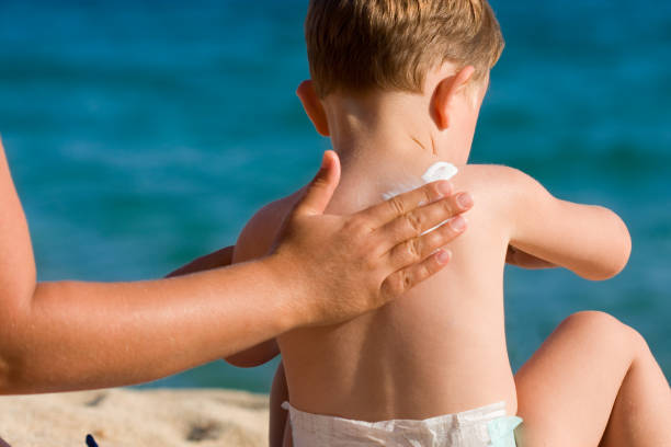 istock Mom applying sunscreen on baby's back 184934524