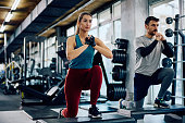 Young athletic couple exercising together in a gym.