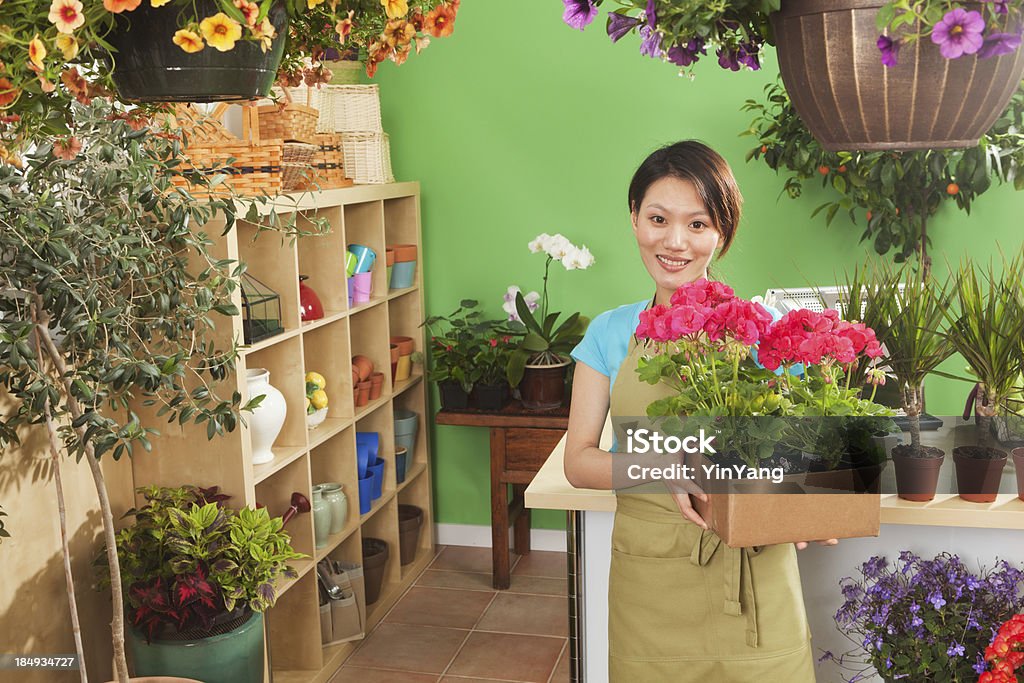 Joven mujer asiática comercial de propietario del centro de jardinería Hz - Foto de stock de Geranio libre de derechos