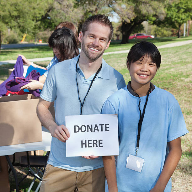 istock Volunteers holding a donate here sign 184935395