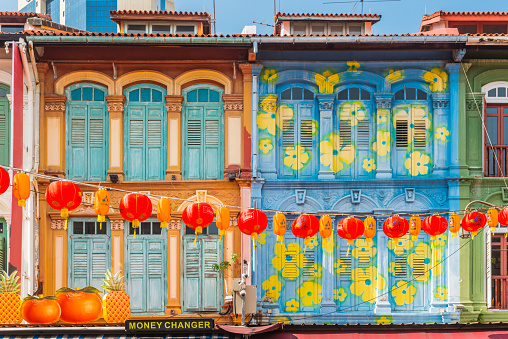 Traditional shophouses painted in a row bright colours in the central Chinatown district of Singapore.