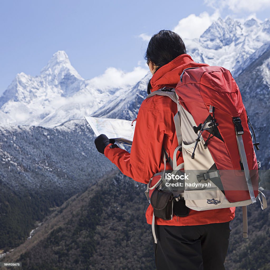 Woman trekking in Mount Everest National Park, Nepal "Mount Everest National Park. This is the highest national park in the world, with the entire park located above 3000m. This park includes three peaks higher than 8,000 m, including Mt Everest. Therefore, most of the park area is very rugged and steep, with its terrain cut by deep rivers and glaciers." Achievement Stock Photo