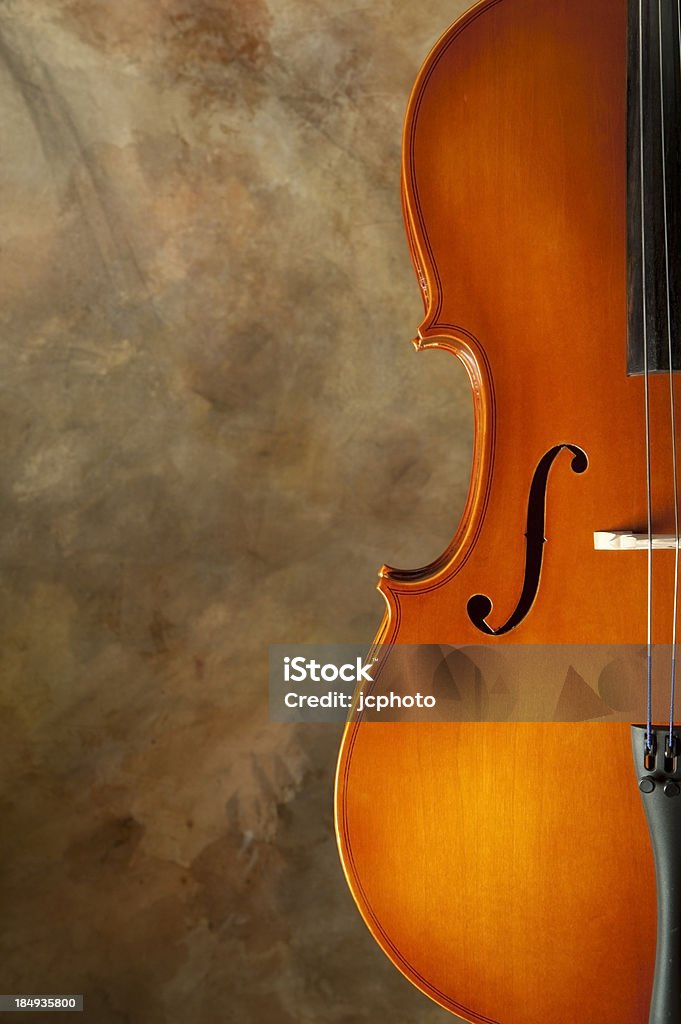 Cello Close up of half of a cello on a warm toned painted canvas backdrop Bass Instrument Stock Photo