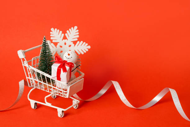 istock White shopping cart with Christmas decorations on red background, copy space 1849363416