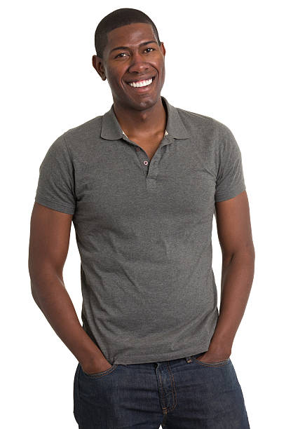 grinning young man standing - polo shirt african ethnicity men african descent fotografías e imágenes de stock