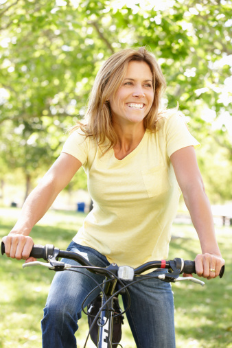 Woman riding bike smiling off camera