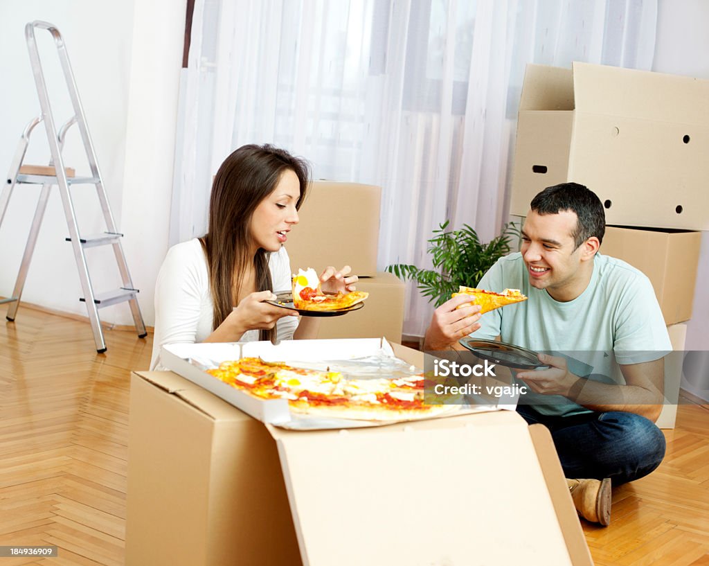 Пара переезда в новый дом ест пицца - Стоковые фото 20-29 лет роялти-фри