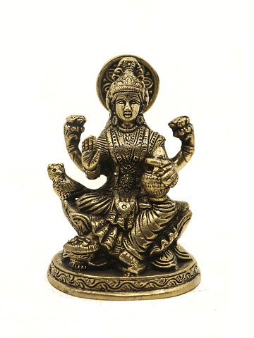 hindu goddess mahalakshmi antique idol with four hands isolated in a white background
