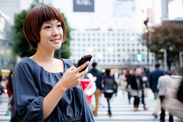 jovem mulher usando smartphone - rush hour commuter on the phone tokyo prefecture imagens e fotografias de stock