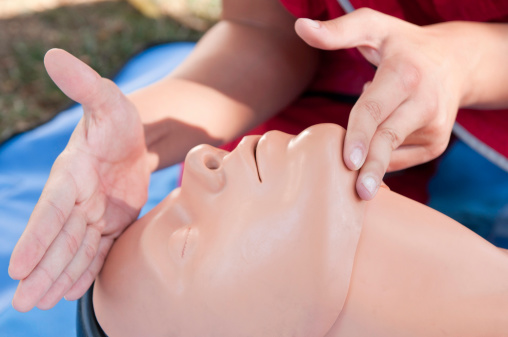 CPR practitioner carefully positioning casualty head during resuscitation procedure. Focus on handsUniform your project with related images: